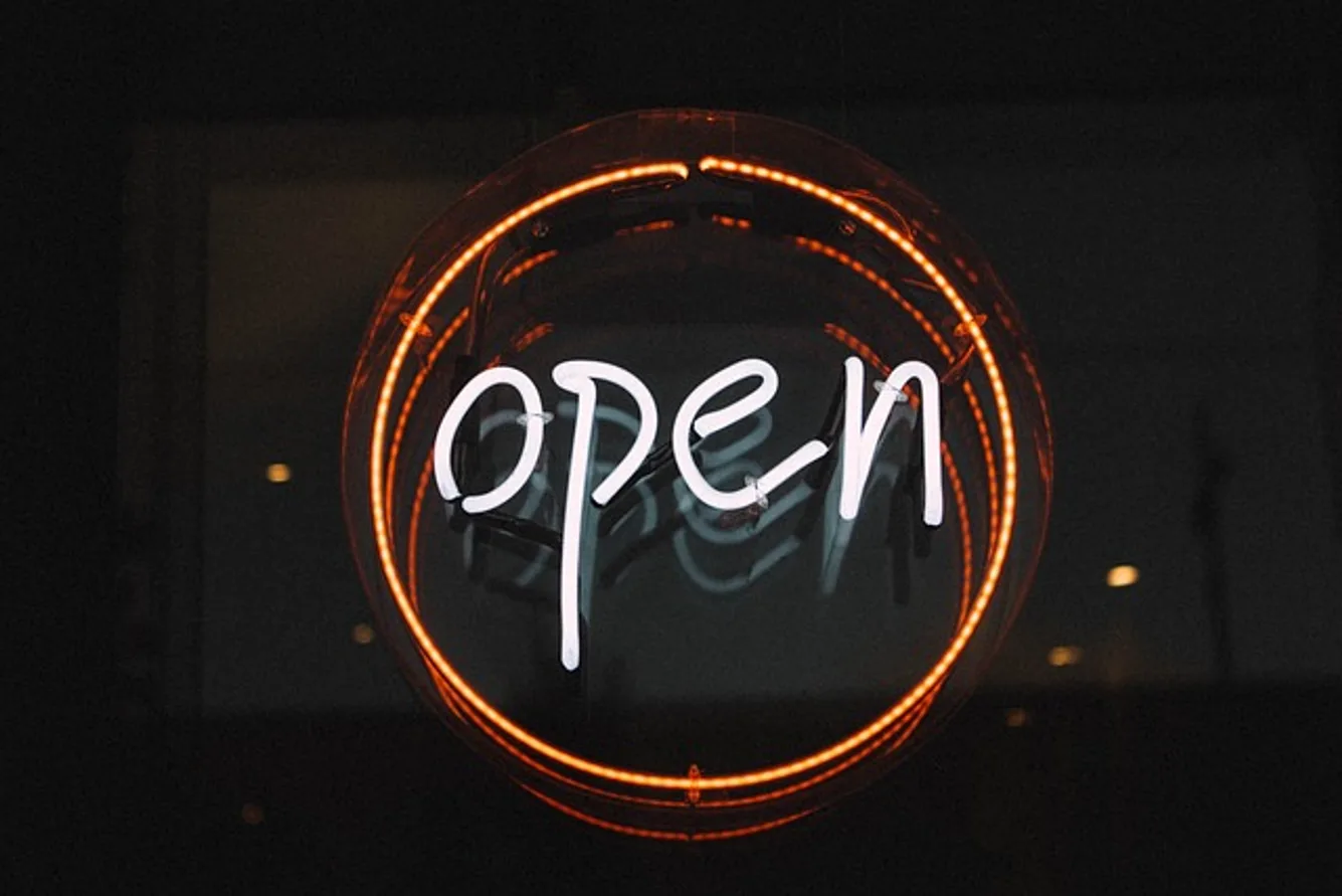 Cartel luminoso de "Open" en el escaparate de un comercio